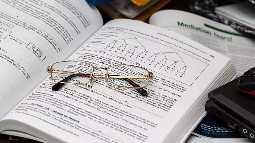 Photo of a glasses on top of a book, from pexels